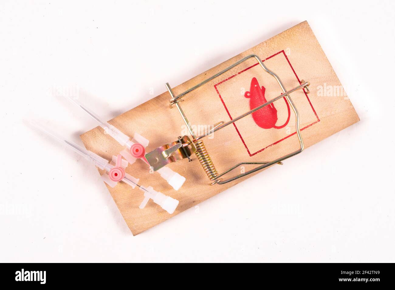 Medical venflon placed in a mousetrap. Medical accessories as a trap for patients. Light background. Stock Photo
