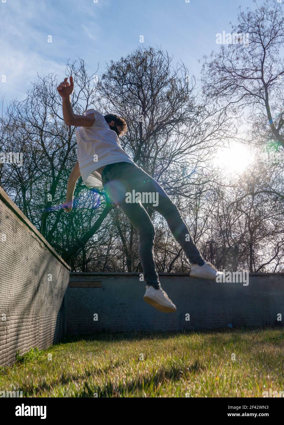 Silhouette of free runner man  performing tricks in a park.  Parkour, free running, youth, sport and lifestyle concept Stock Photo