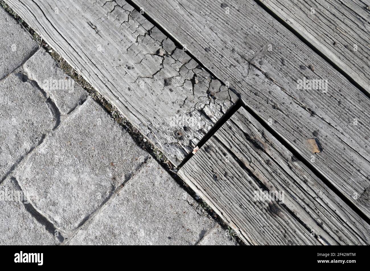wood dock and cobblestone textures combine in late afternoon sun. Stock Photo