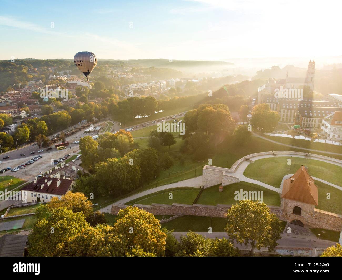 VILNIUS, LITHUANIA - AUGUST 20, 2020: Colorful hot air balloons taking off in Old town of Vilnius city on sunny summer morning. Lots of people watchin Stock Photo