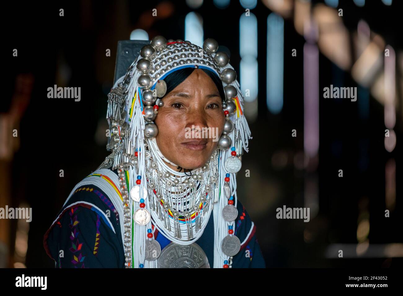 Headshot of smiling woman of Akha tribe inside her house, near Kengtung, Myanmar Stock Photo