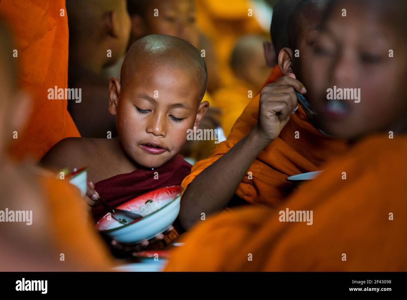 Novice monks eating lunch at Ko Yin Lay Monastery near Kengtung, Myanmar Stock Photo