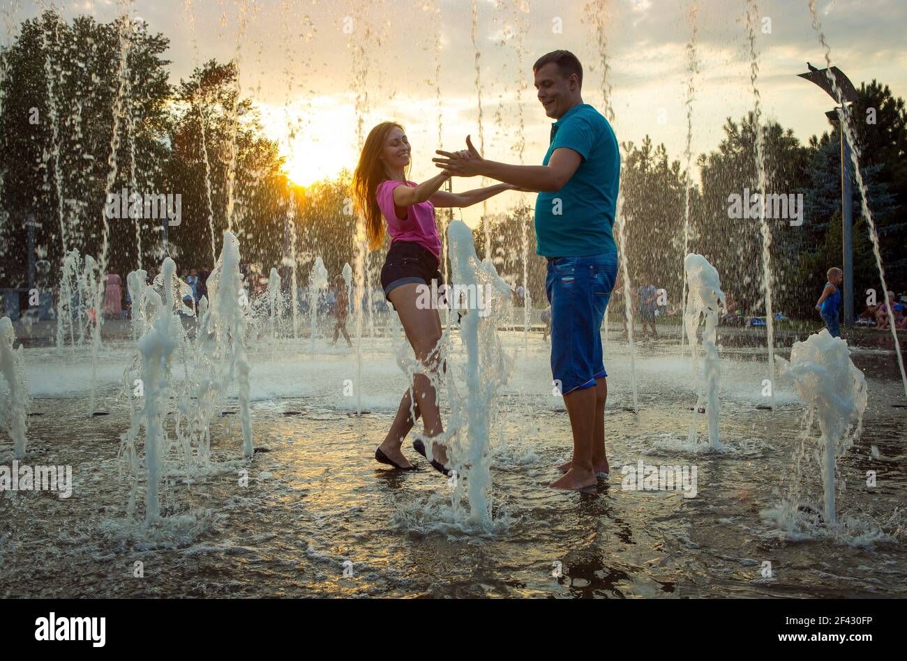 Dnepropetrovsk, Ukraine - 08.20.2017: Joyful townspeople dance on the square in the city at sunset. A couple of young people are dancing under the fou Stock Photo