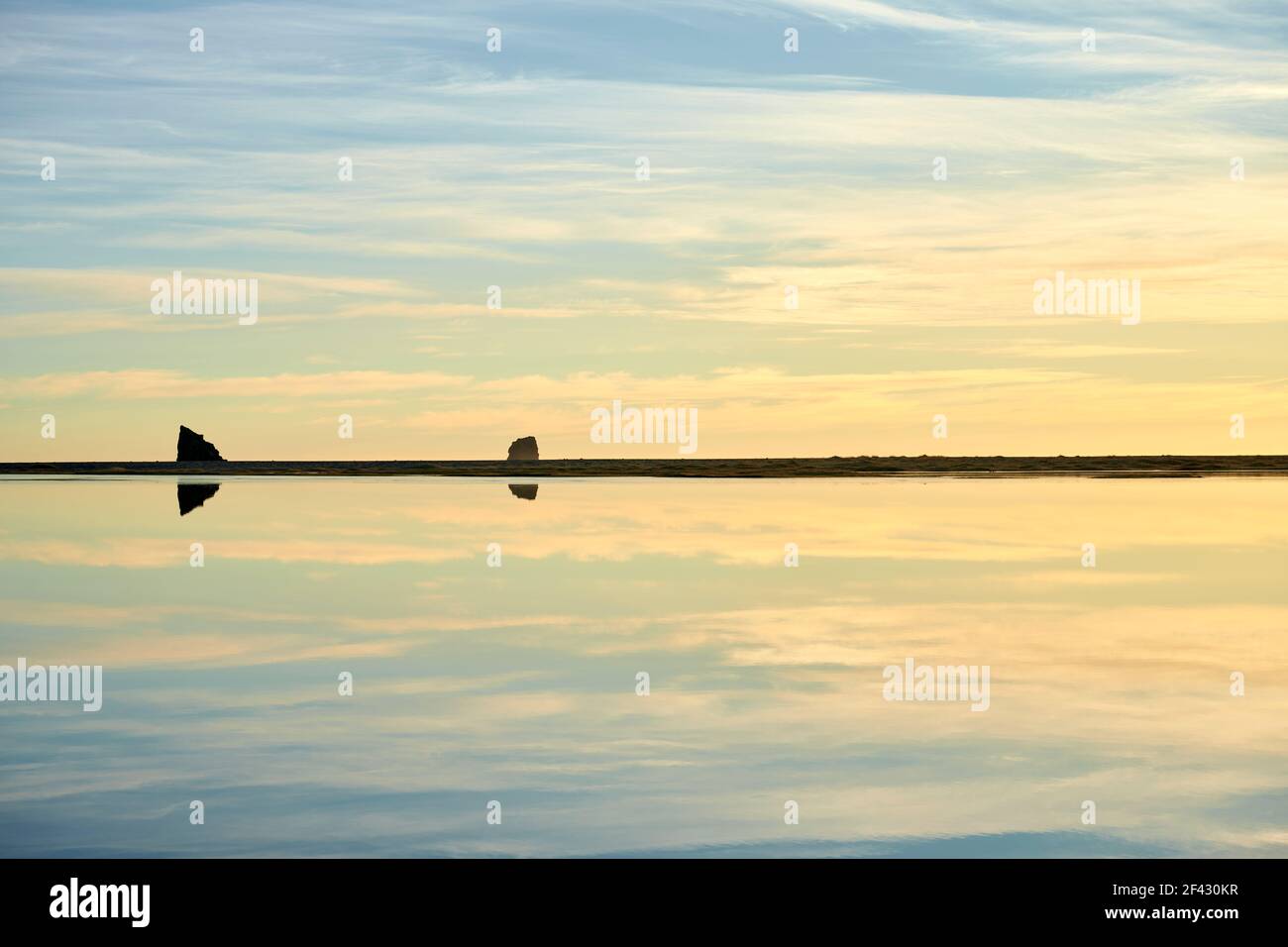 Cloudy morning sky reflecting in sea water Stock Photo