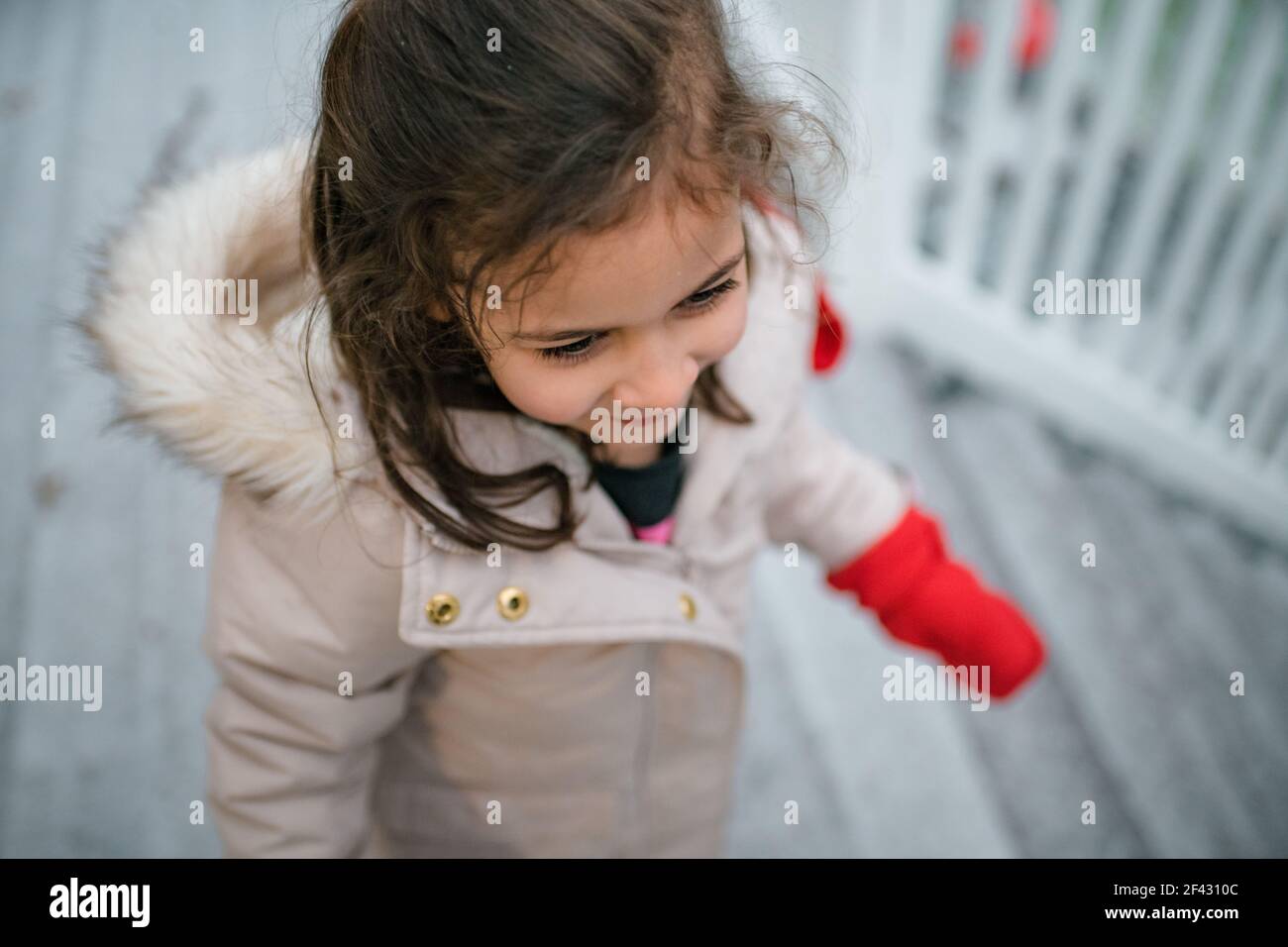 Young happy girl outside in winter coat and mittens Stock Photo