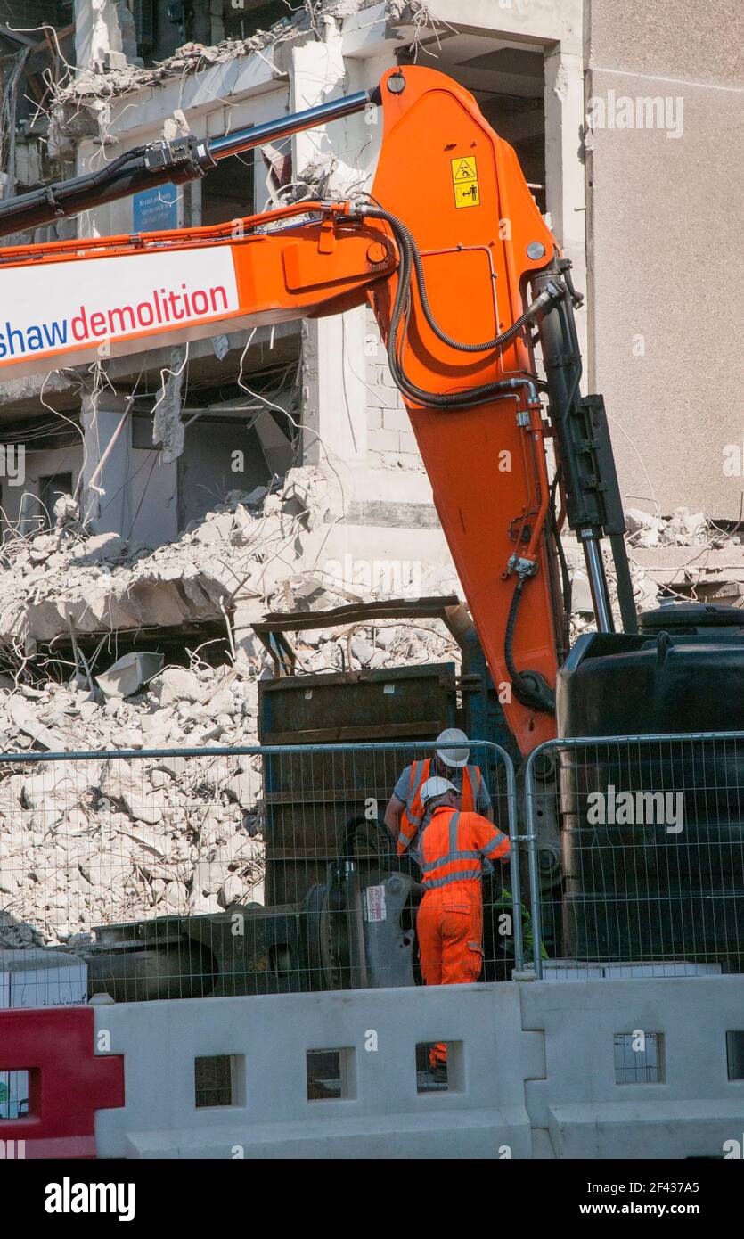 Workmen inspecting problem on hydraulic jaws being used on the demolition of Wilko store and multi storey car park Talbot road Blackpool Lancashire UK Stock Photo