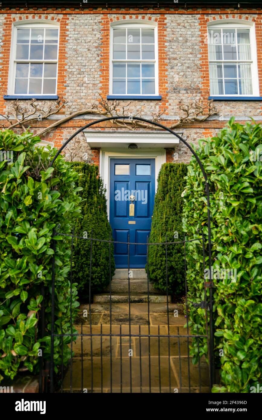 Thame, UK 11 Oct 2020: A bricked Lashlake House entrance with royal blue color door and beautiful greenery around, British 19th-century Queen Anne sty Stock Photo