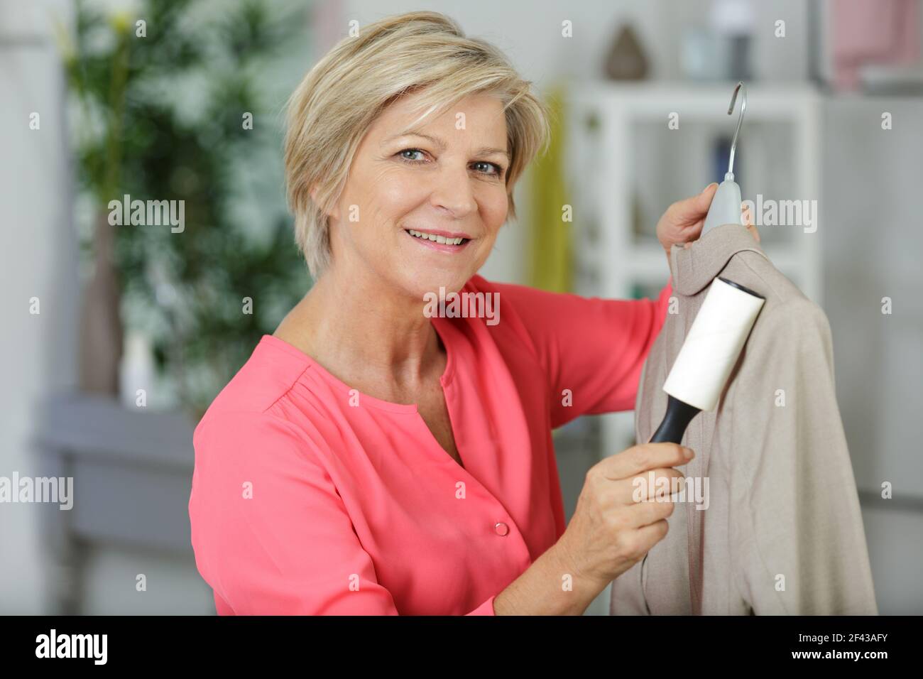 woman removing dog and cat hair from clothes Stock Photo Alamy