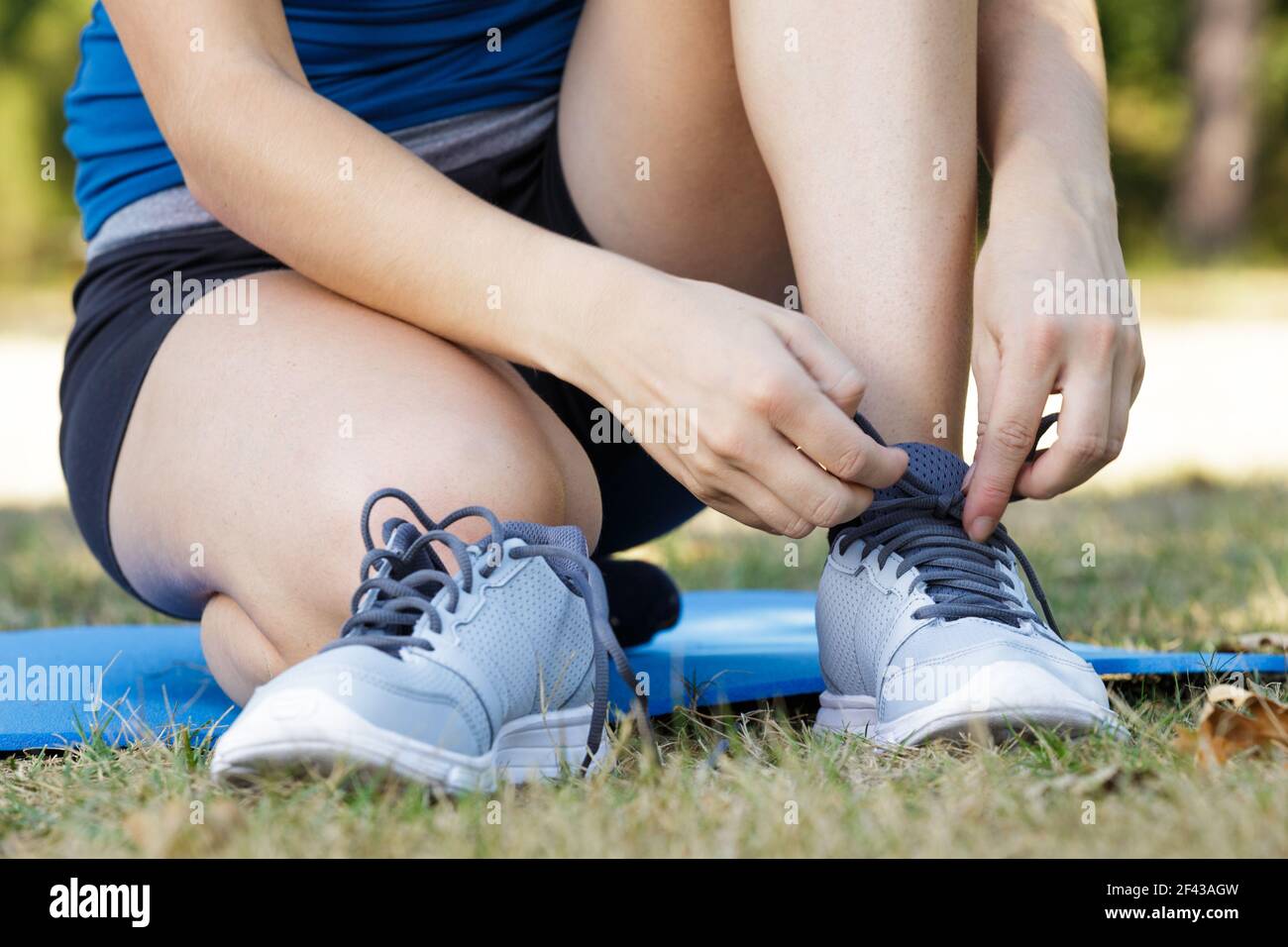 female hands tying shoelace on running shoes before practice Stock ... - Soft Laces For Improved Finger Grip During Shoelace Tying