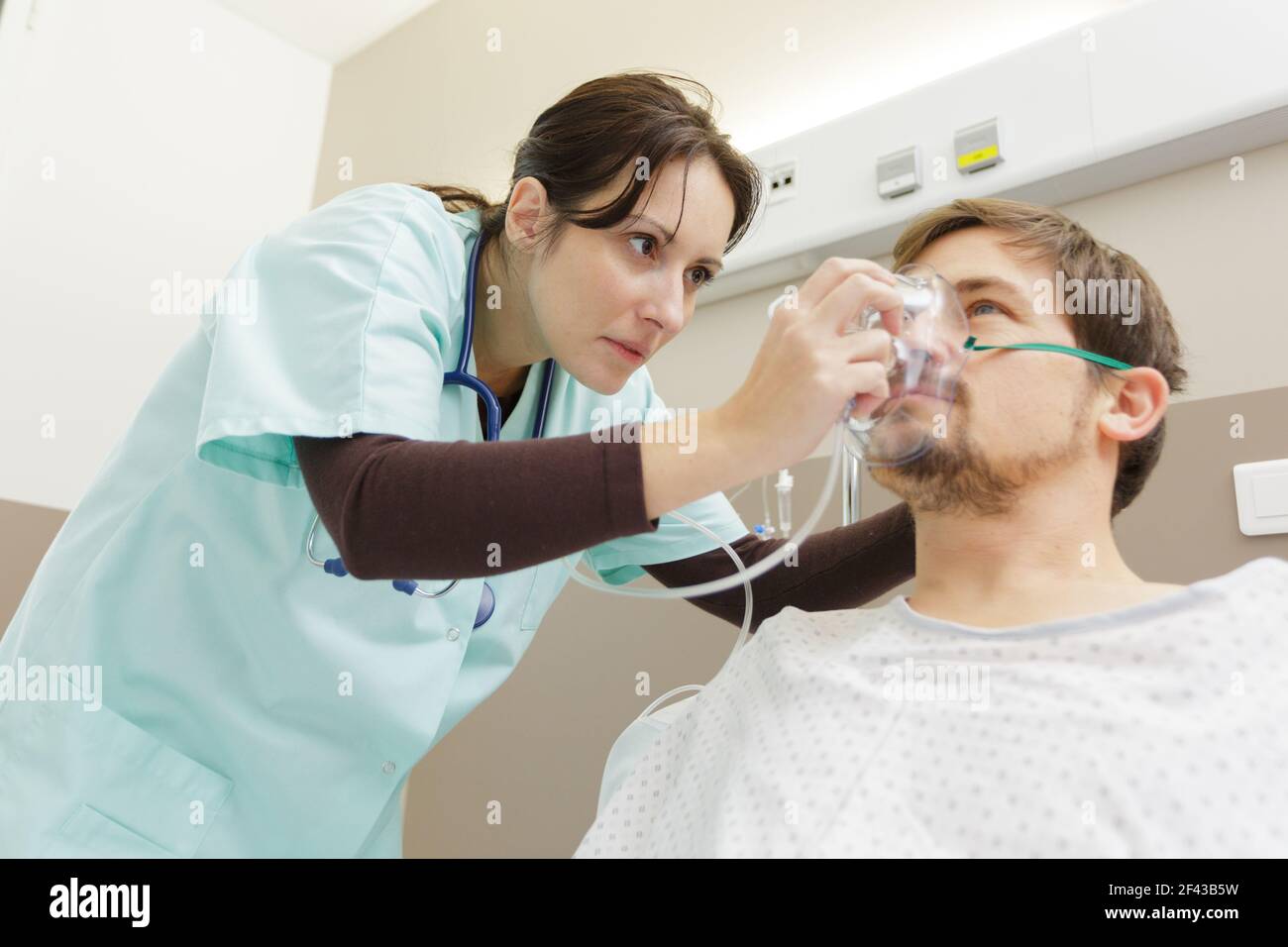nurse placing oxygen mask on patient in hospital Stock Photo Alamy