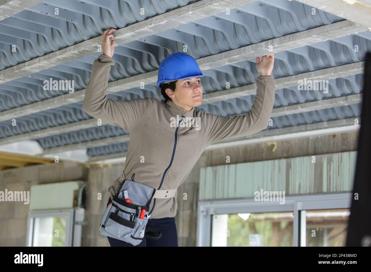 female worker screwing something in the ceiling Stock Photo - Alamy