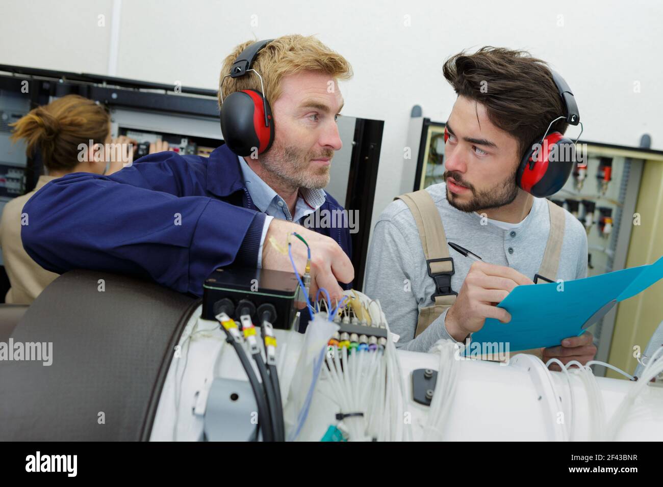 two young engineers working with electronics details Stock Photo