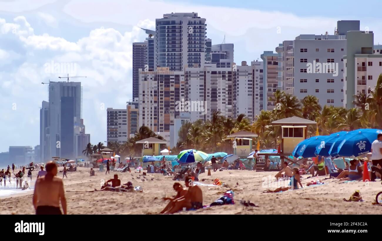 Tourists with colorful beach umbrellas on Dania Beach, with hotels and condos in the background, Fort Lauderdale, Florida, USA Stock Photo