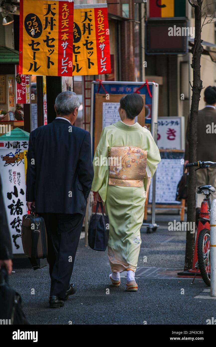 Full length, rear view of Japanese female walking through Ginza wearing