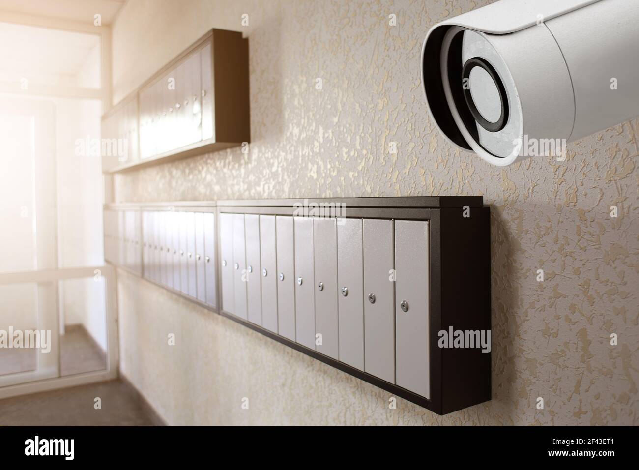 Modern CCTV camera installed in entryway of apartment building Stock