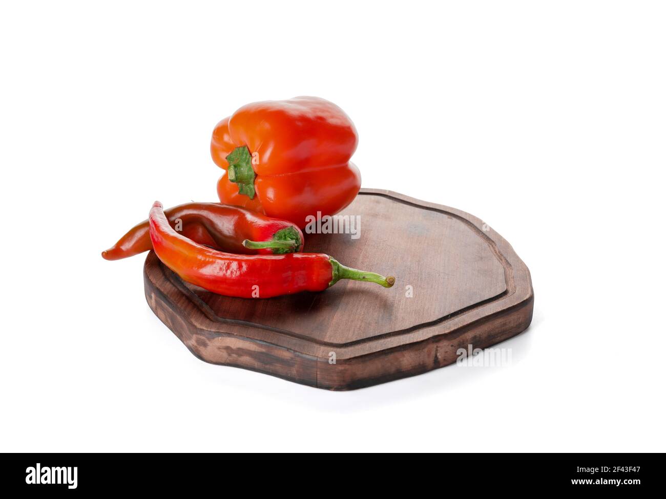 Cutting board with bell and chili peppers on white background Stock ...