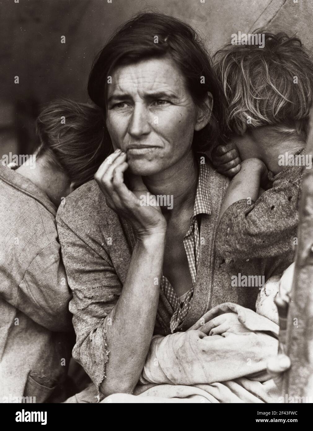 Migrant agricultural worker's family. Seven hungry children. Mother aged thirty-two. Father is native Californian. Nipomo, California Photo shows Florence Thompson with several of her children in a tent shelter as part of the ' Migrant Mother ' series. March 1936.Photograph by Dorothea Lange. Stock Photo