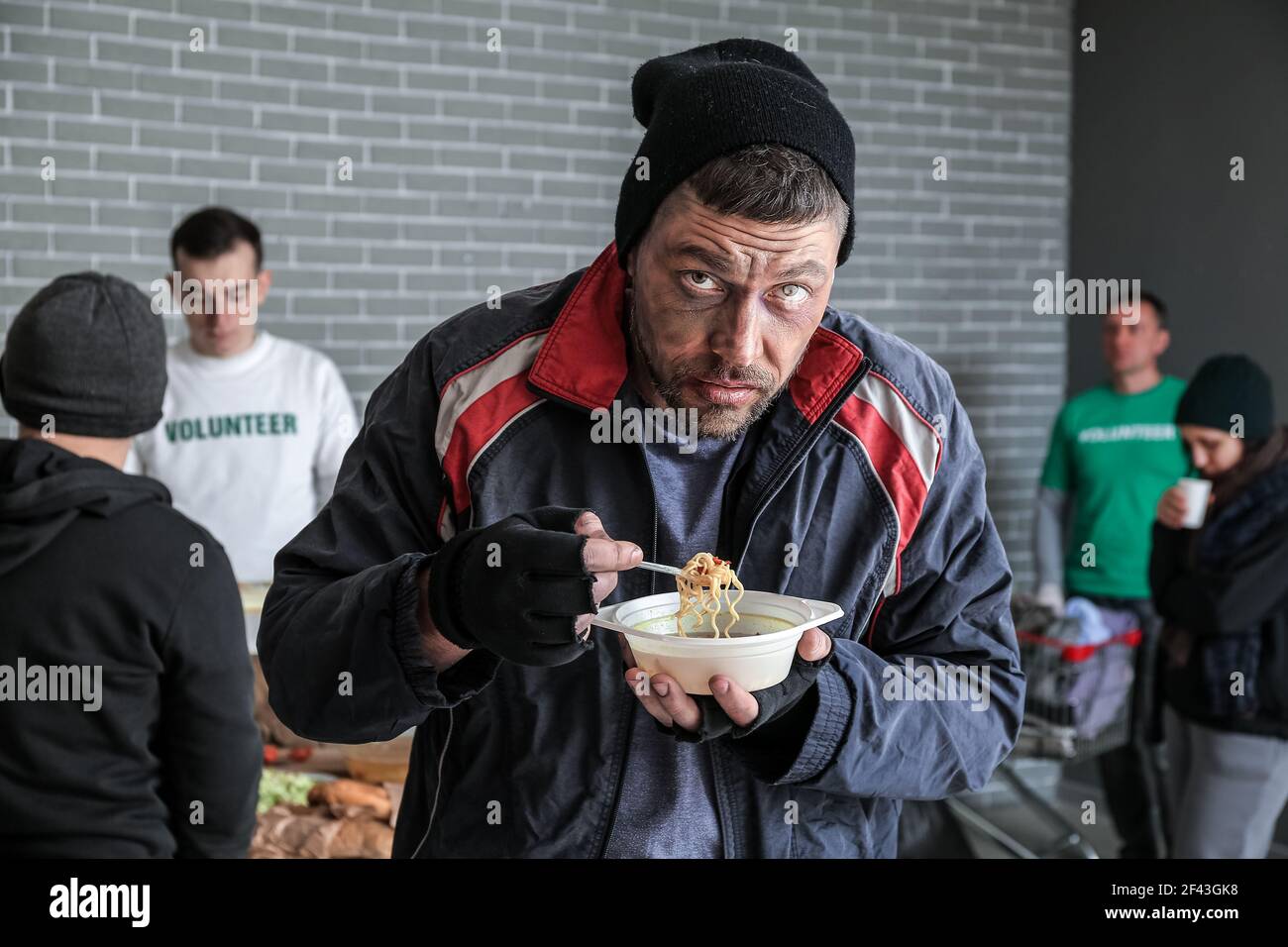 Poor homeless man with hot food in warming center Stock Photo - Alamy