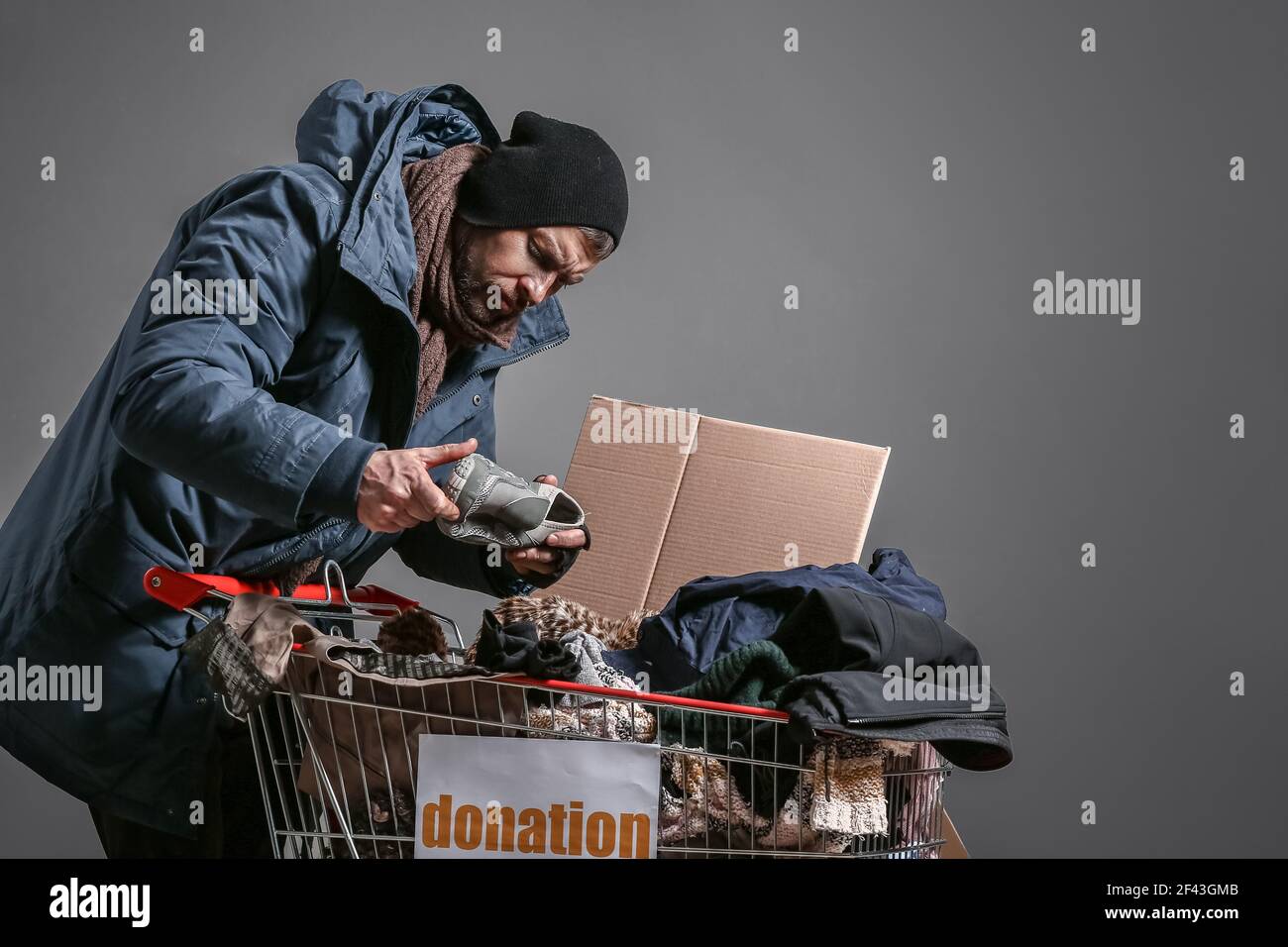 Poor homeless man with donations on grey background Stock Photo Alamy