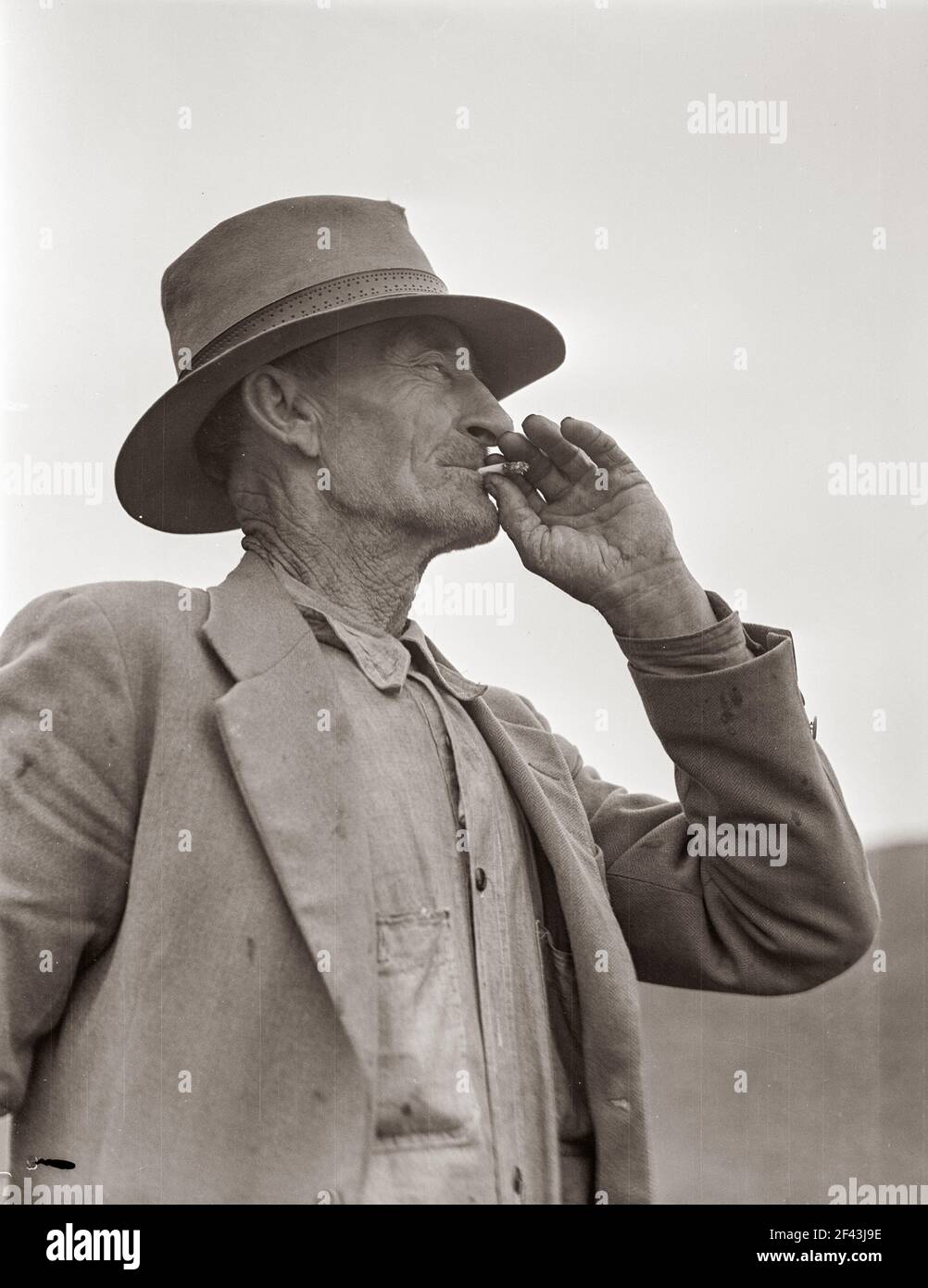 This man is a labor contractor in the pea fields of California. 'One-Eye' Charlie gives his views. 'I'm making my living off of these people (migrant laborers) so I know the conditions.' San Luis Obispo County, California. February 1936. Photograph by Dorothea Lange. Stock Photo