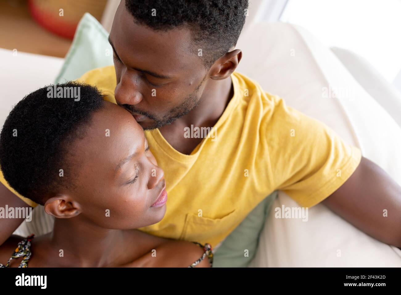 African american couple sitting on sofa embracing Stock Photo