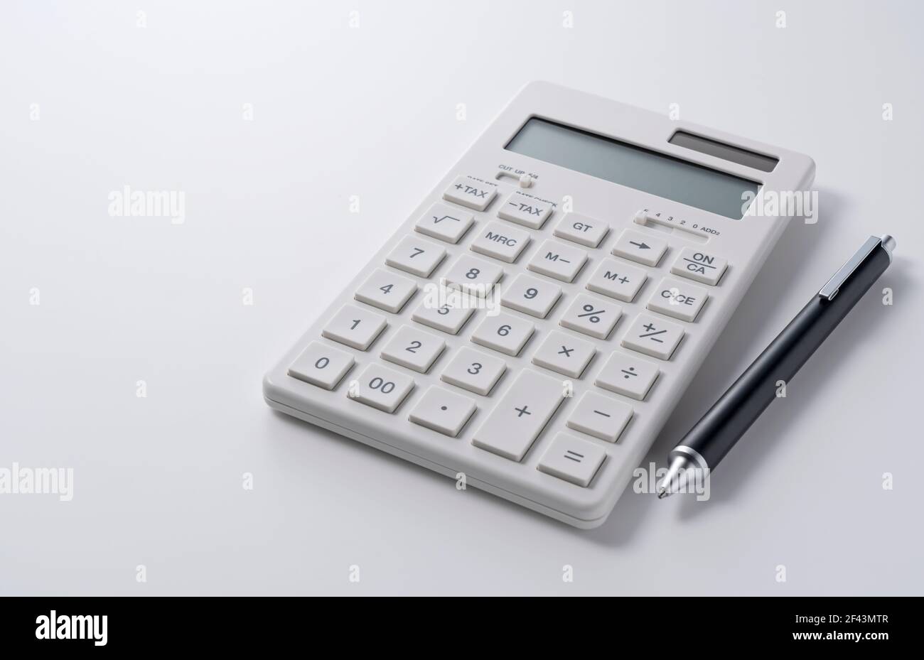A calculator and pen on a white background. Business image Stock Photo