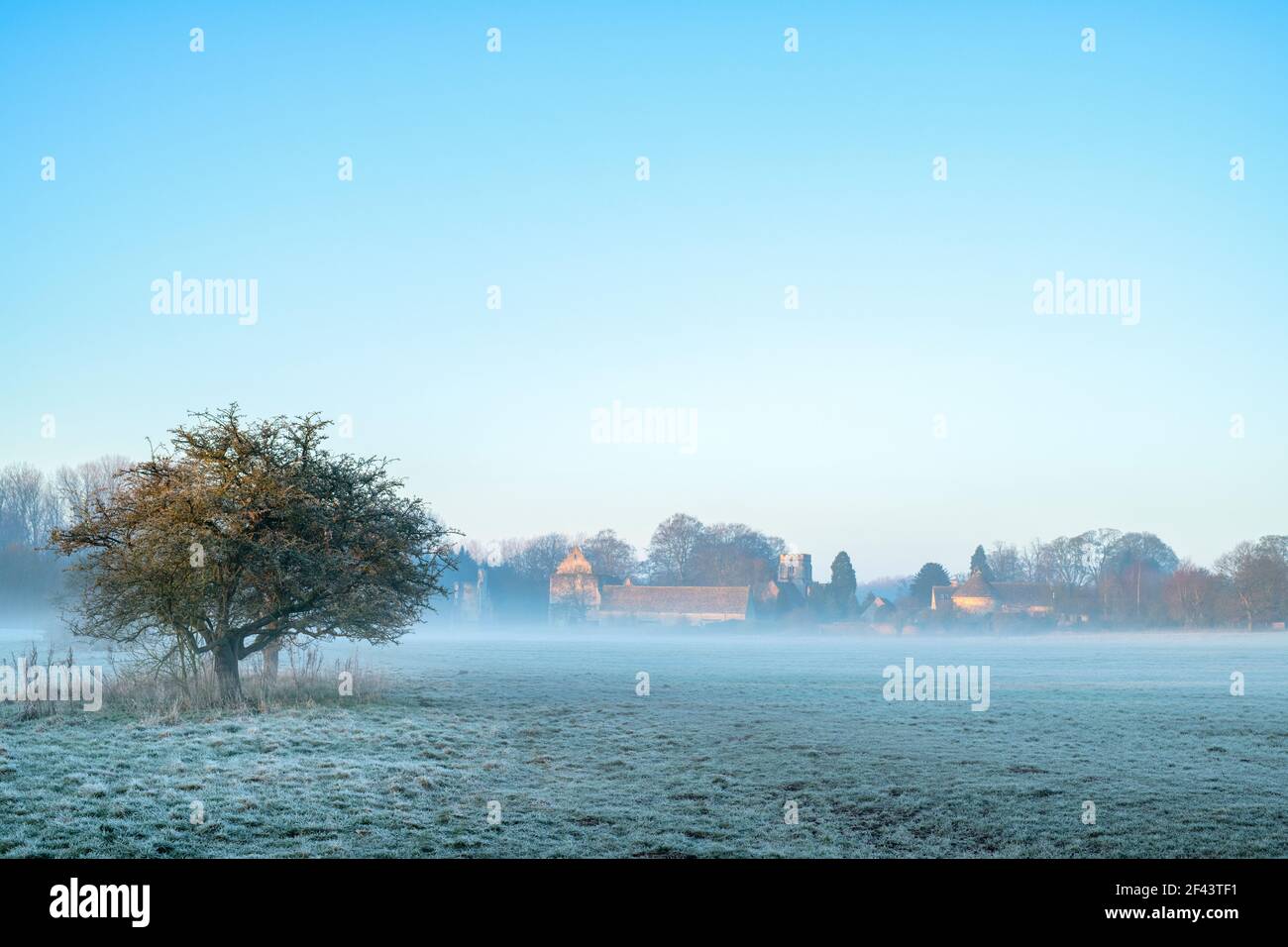 Minster Lovell Hall and village in the mist and frost at sunrise