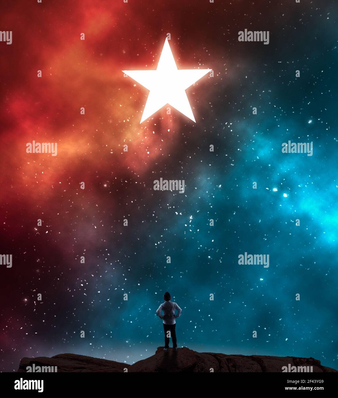 Young man looking at a star during night on a colorful nebula . Stock Photo