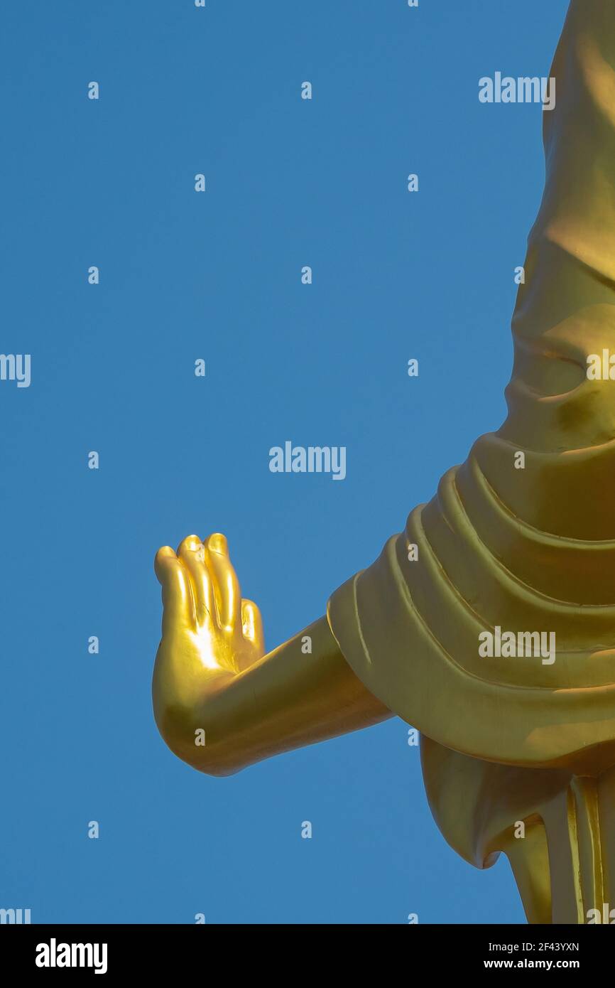 Hand of golden buddha statue with blue sky background on sunlight day ...