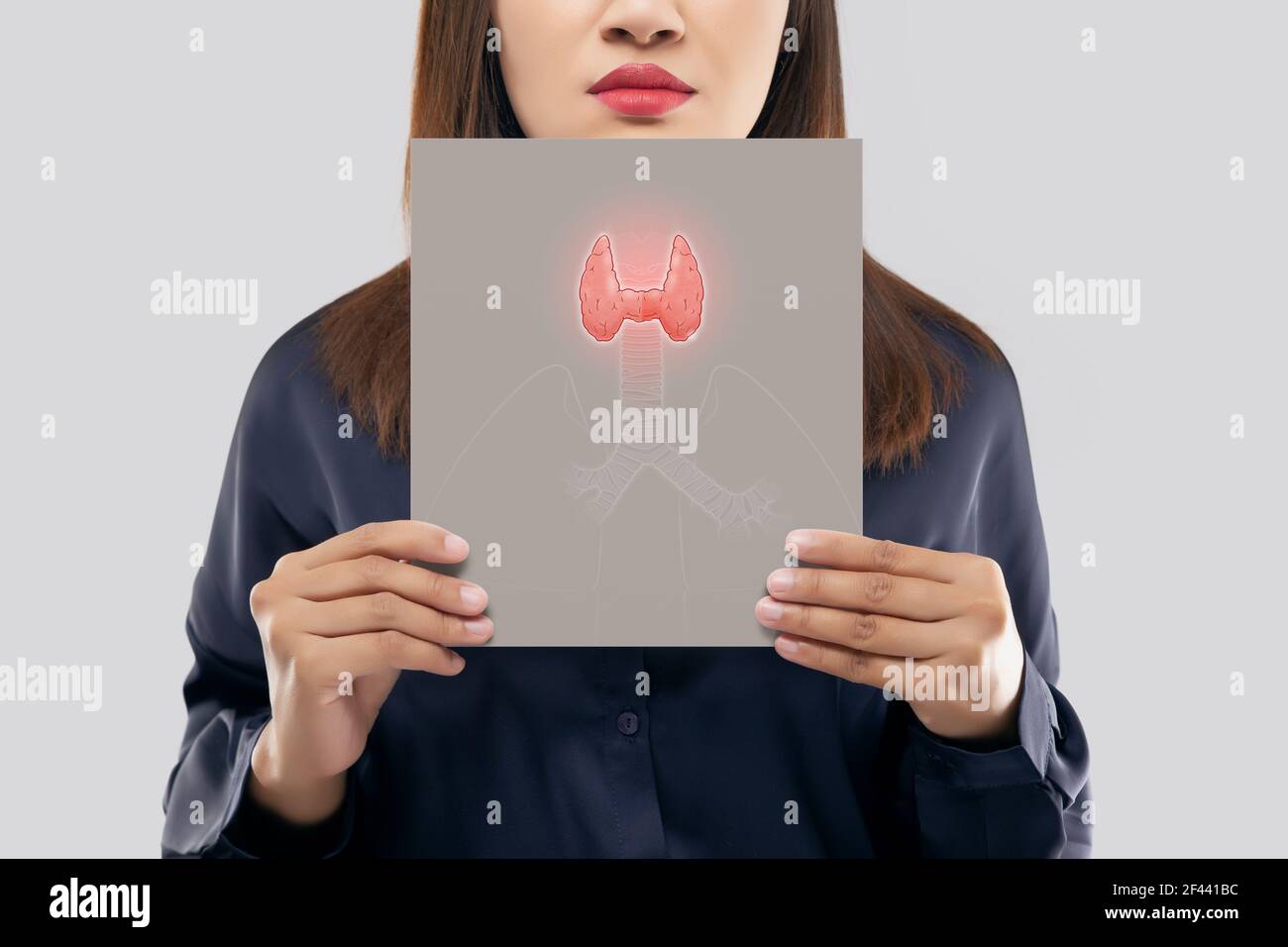 illustration of the thyroid in the gray paper is on the woman's neck. Female thyroid gland control. Sore throat of a people against a light gray backg Stock Photo