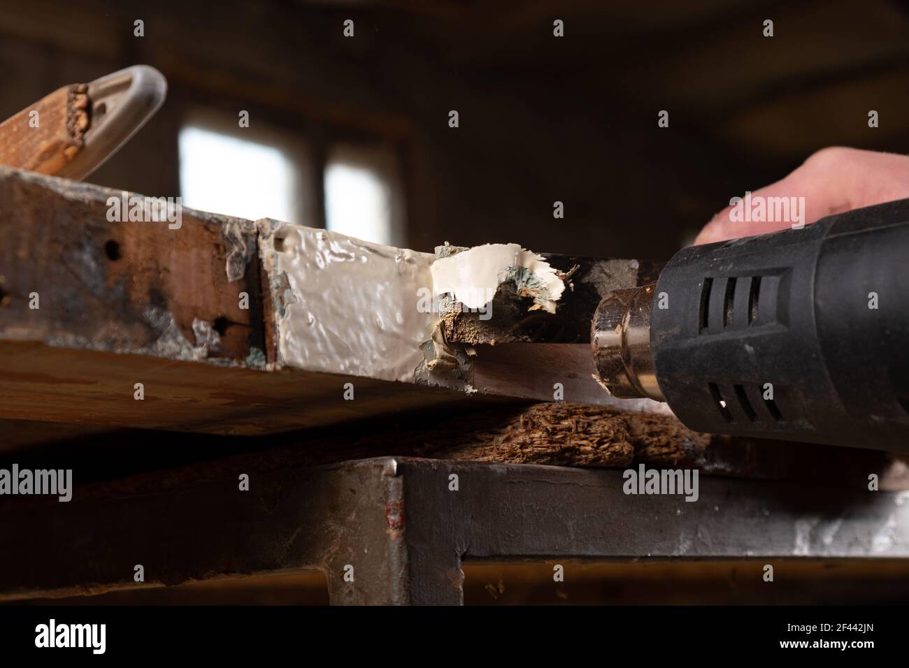 removing old paint from old wooden doors with a spatula and a heat gun