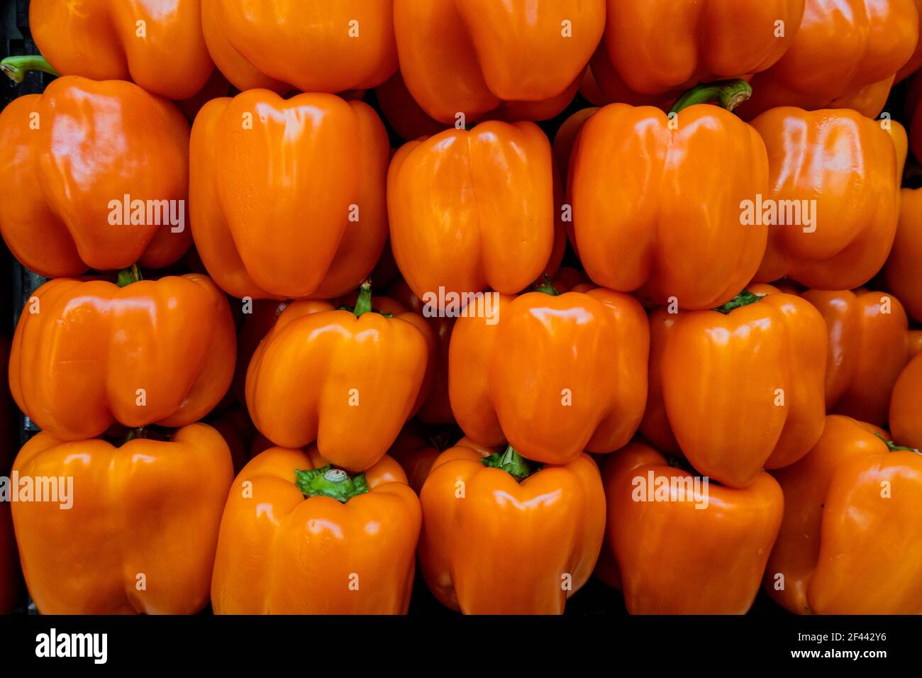 Orange bell peppers in a pile ready for sale Stock Photo - Alamy