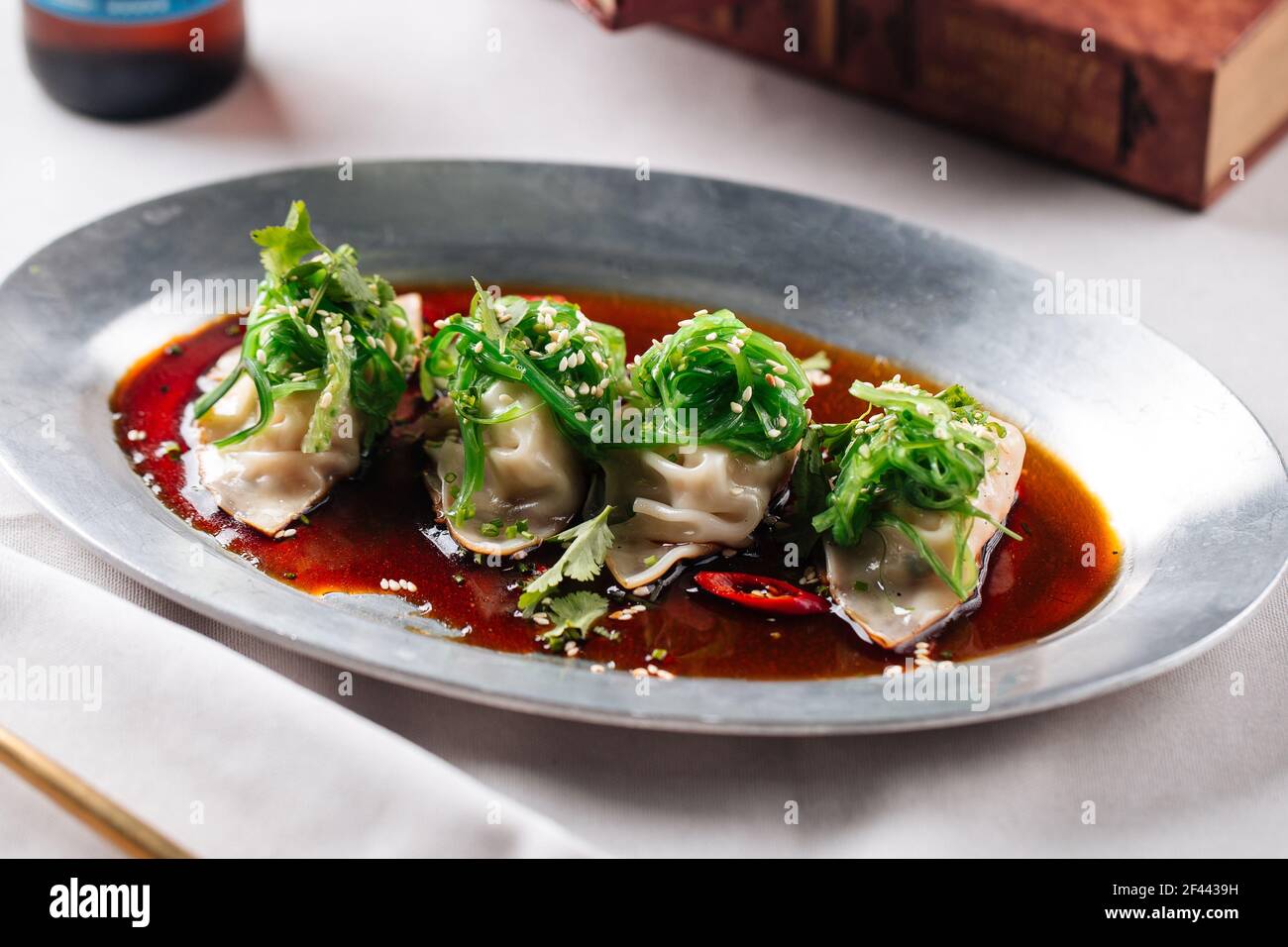 Asian meat stuffed dumplings with sauce in a bowl Stock Photo
