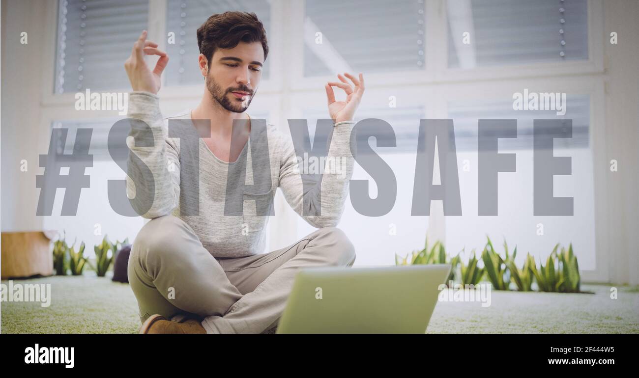 Stay safe text over man practicing yoga and using laptop Stock Photo