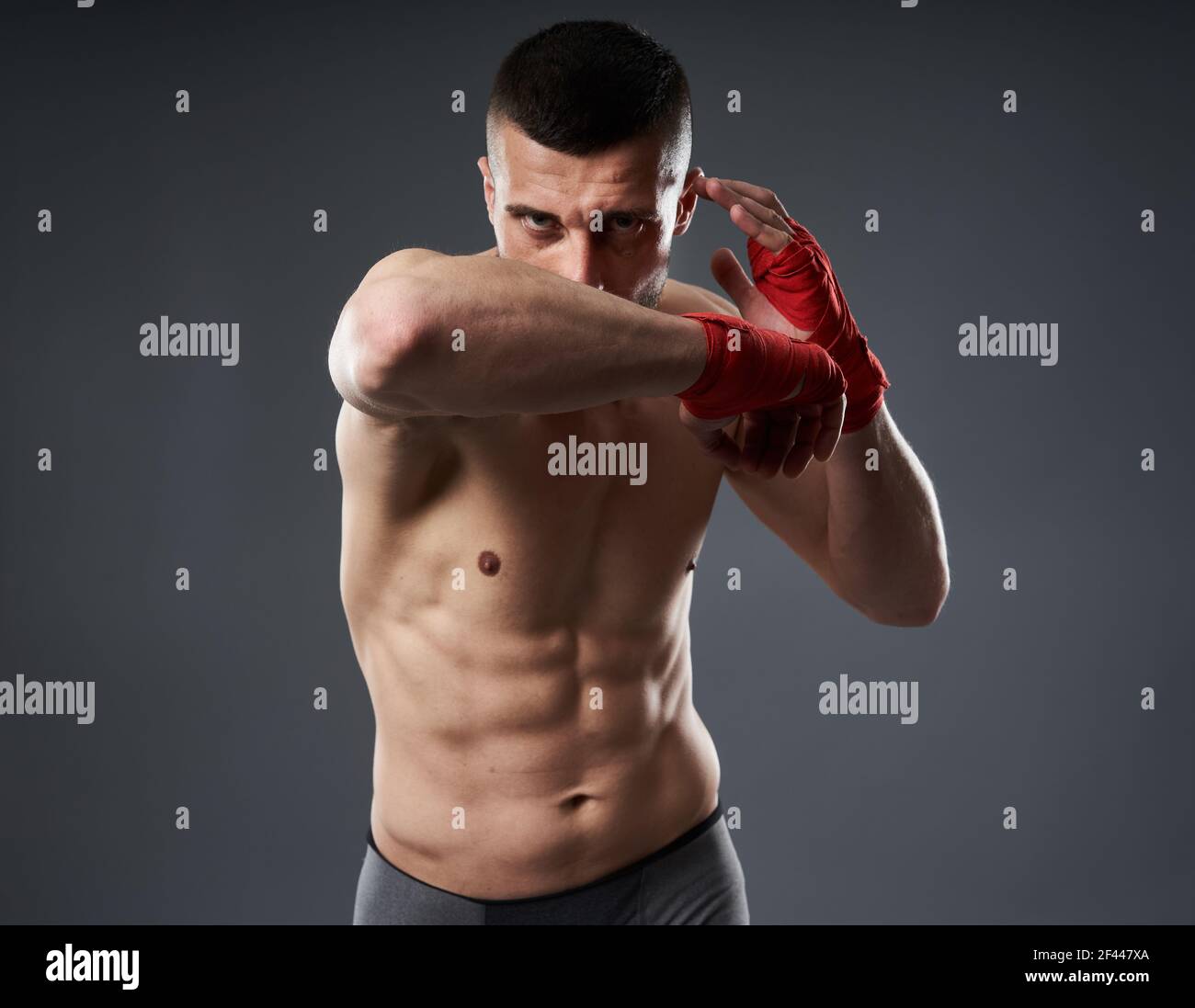 MMA fighter training, throwing an elbow strike, isolated on gray
