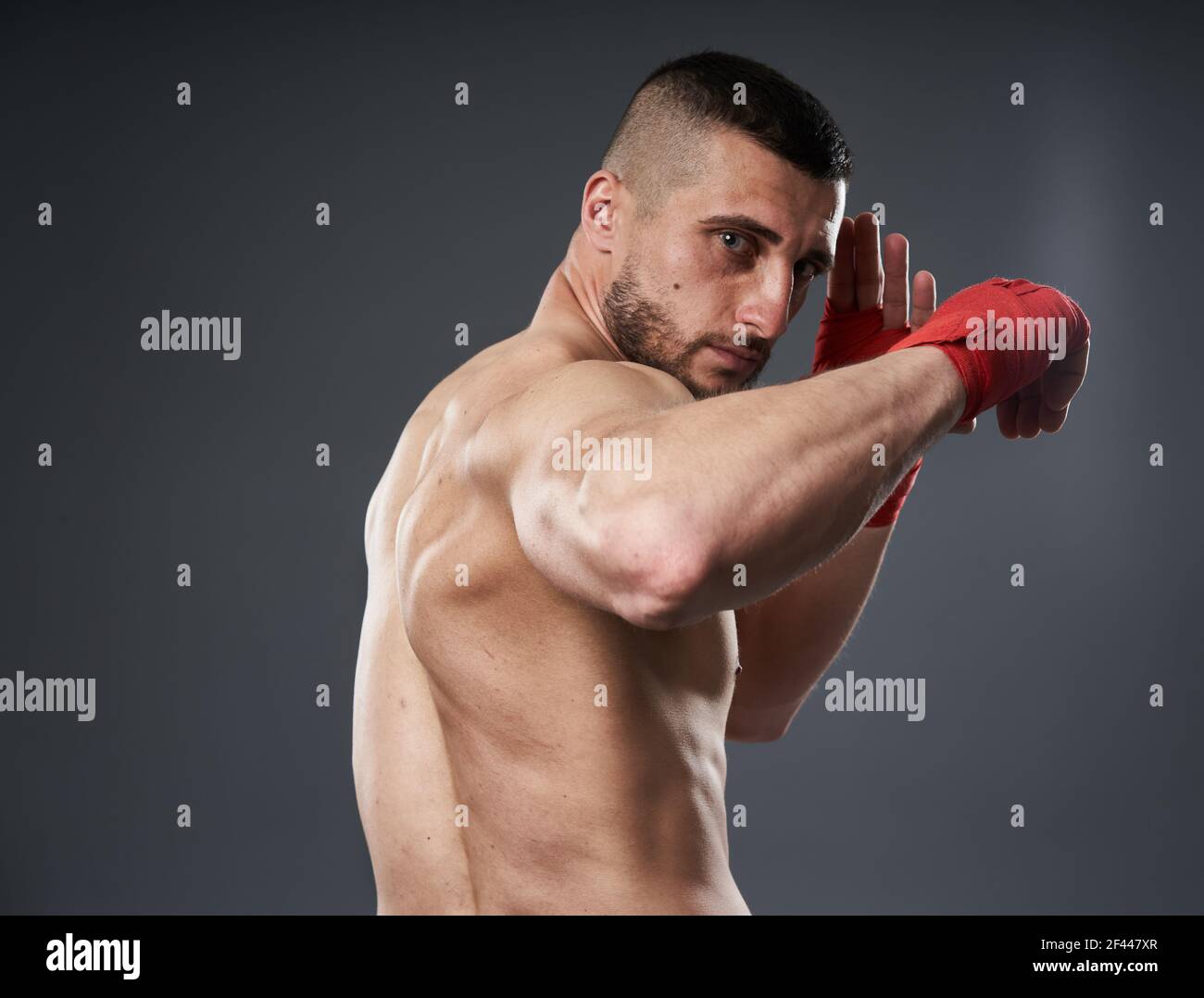 MMA fighter training, throwing an elbow strike, isolated on gray