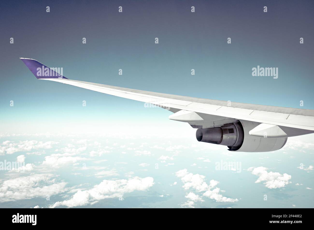 Airplane wing on blue sky background - retro style lighting effect Stock Photo