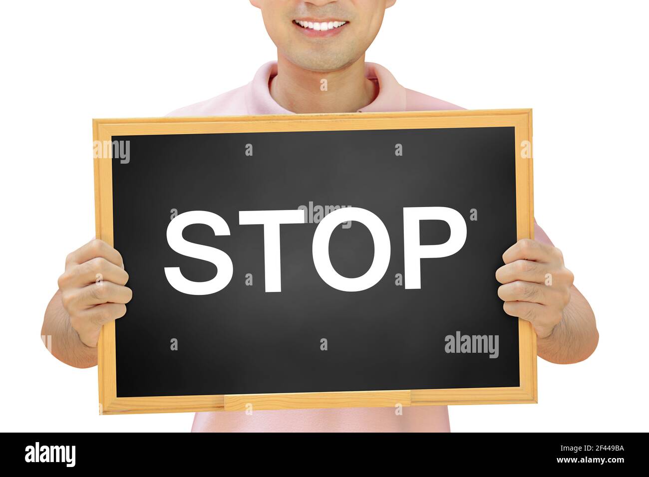 STOP sign on blackboard held by smiling man Stock Photo