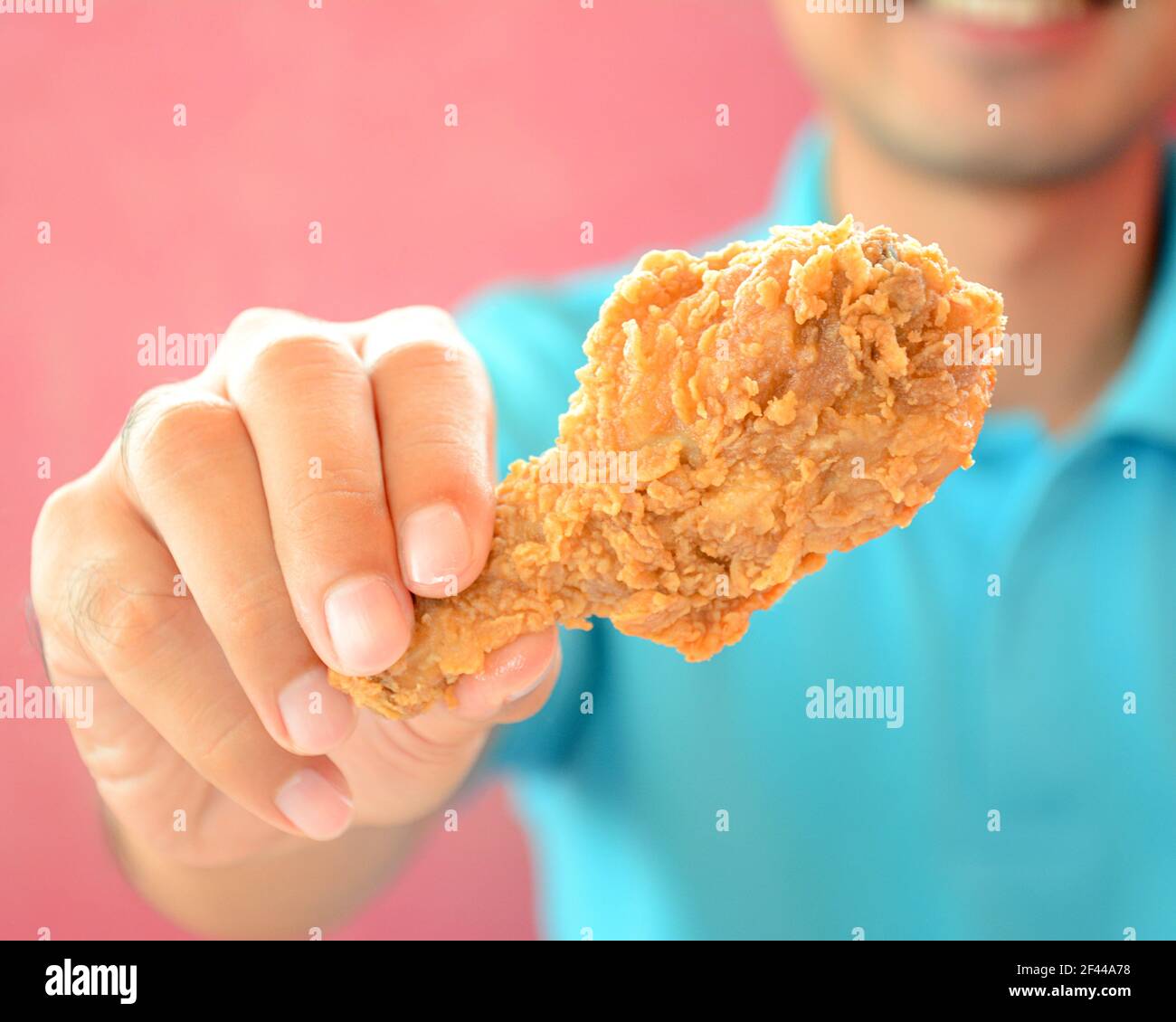 A man giving fried chicken leg or drumstick Stock Photo