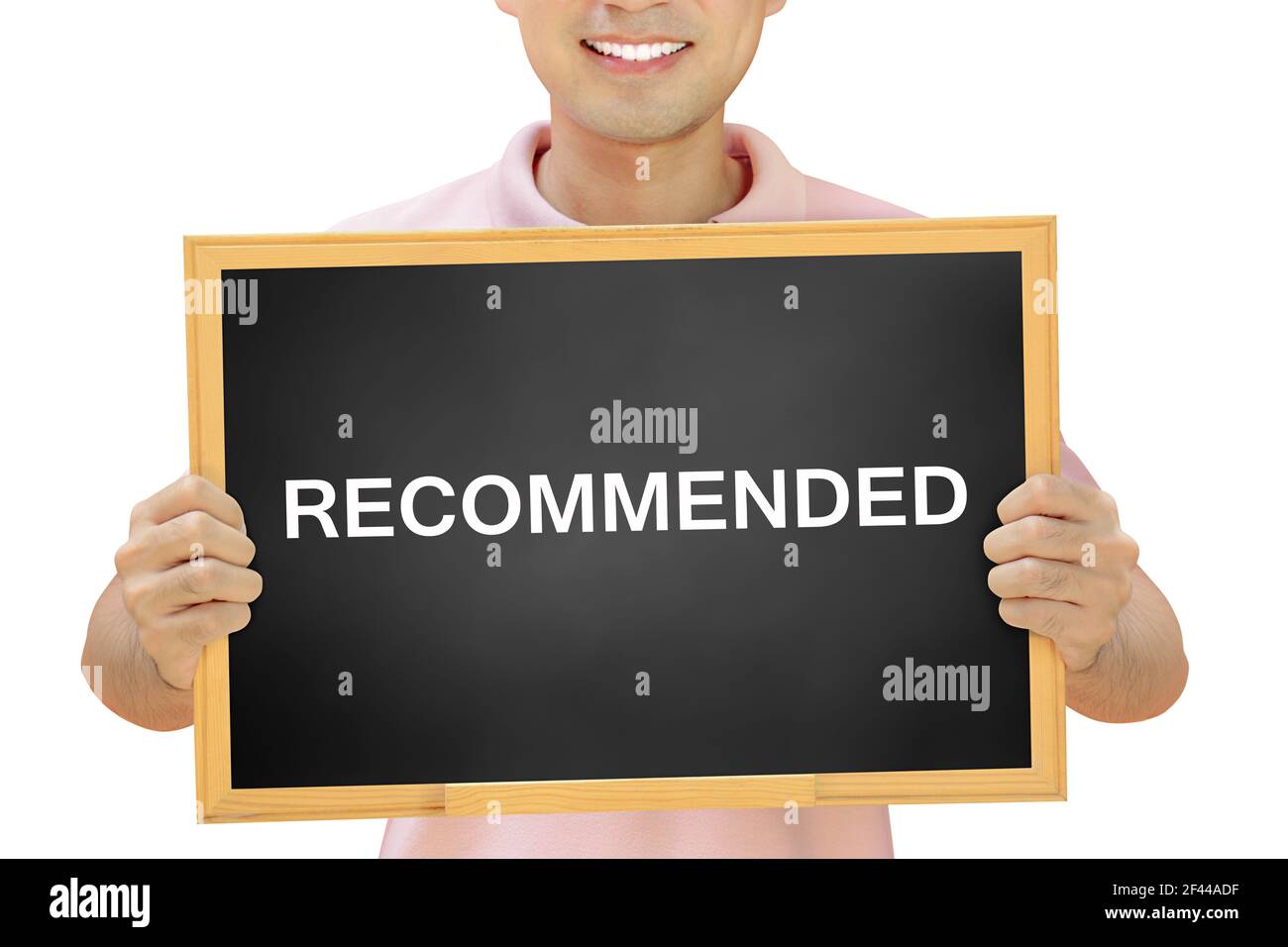 RECOMMENDED word on blackboard held by smiling man Stock Photo