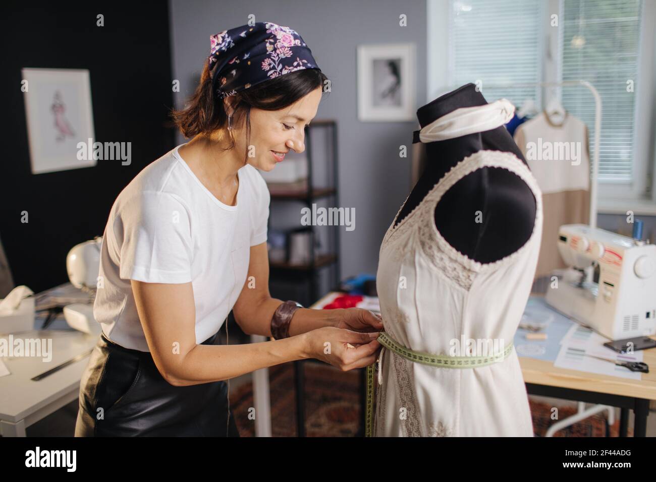 Fashion designer measuring a dress on dummy Stock Photo - Alamy