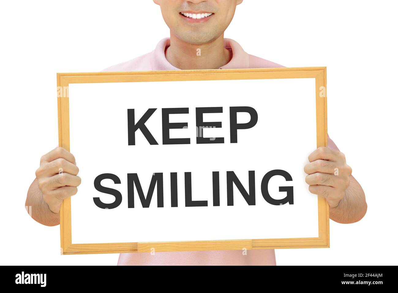KEEP SMILING words on whiteboard held by smiling man Stock Photo