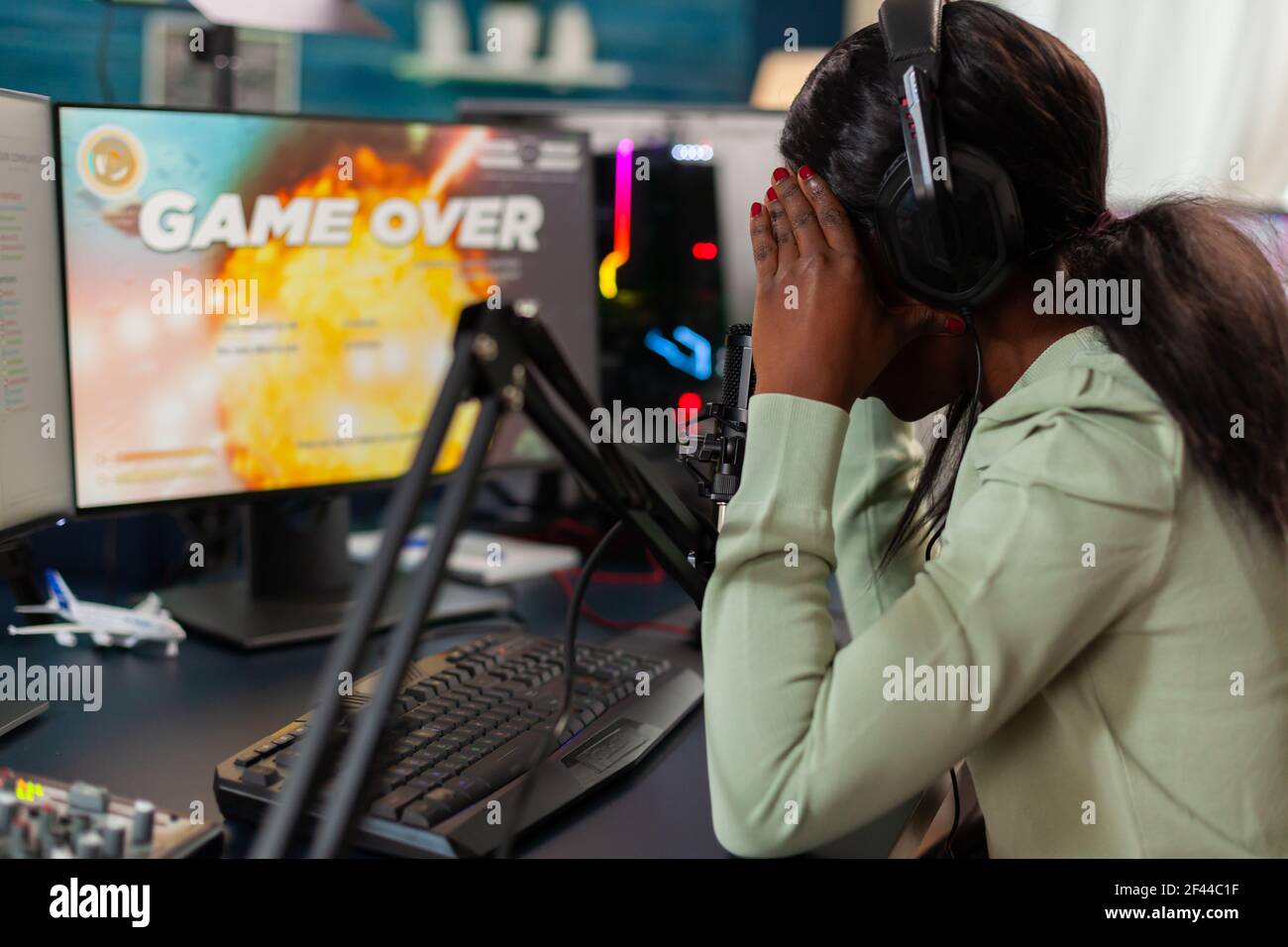 Disappointed african online game streamer losing championship, internet multiplayers. Professional gamer streaming online video games with new graphics on powerful computer. Stock Photo