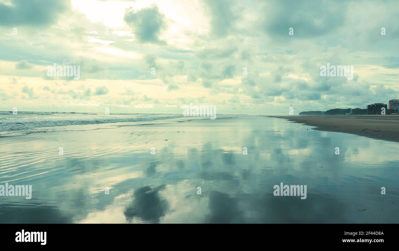 landscape of cox's bazar sea beach . beautiful cloudy sky reflected on wet beach . longest sea beach in the world . Stock Photo