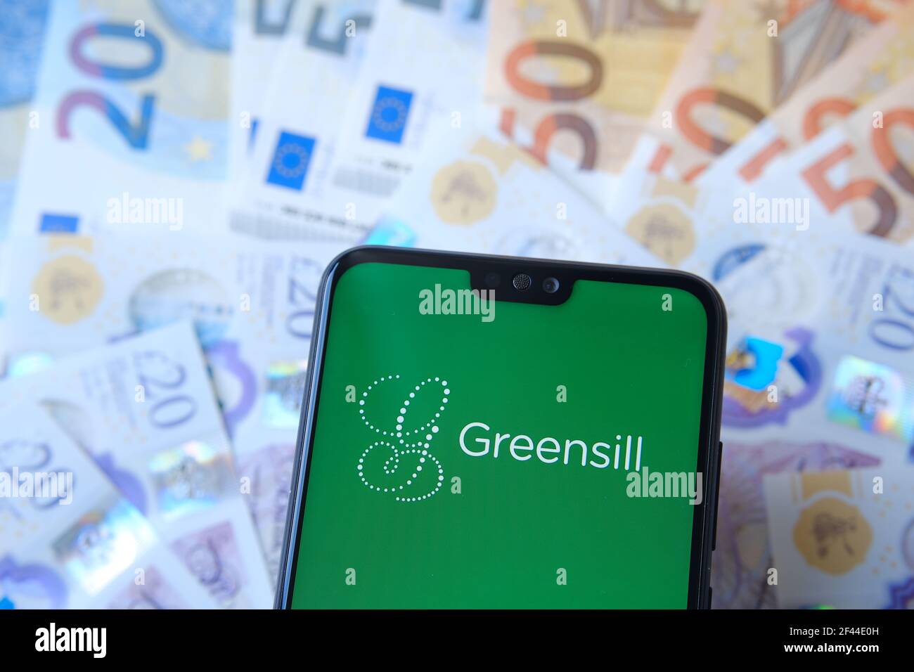 Greensill logo seen on the smartphone and blurred cash on the background. Greensill Capital was a financial services company which filed for insolvenc Stock Photo