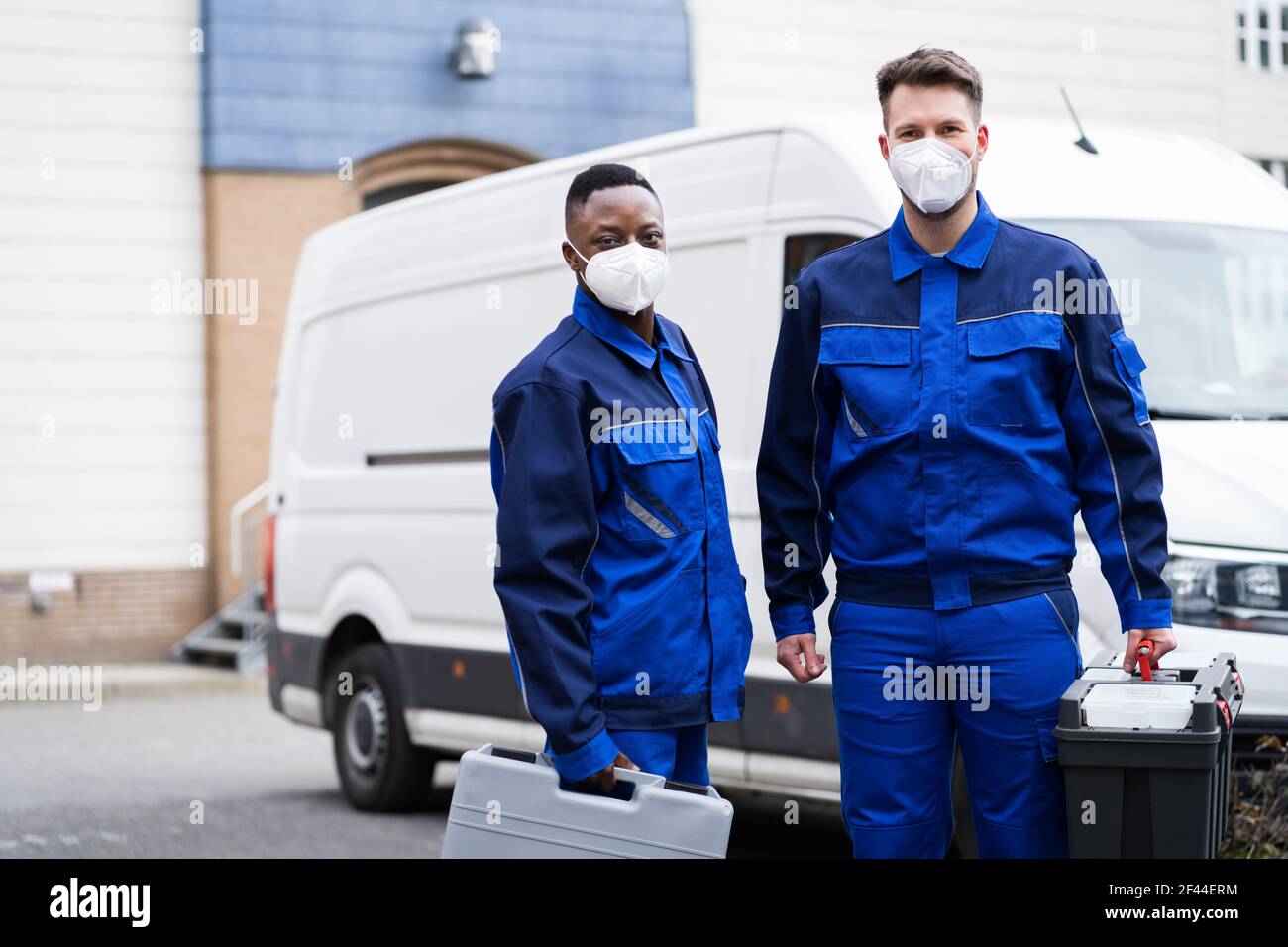 Electrician Technician Or Plumber In Workwear And Face Mask Near Van Stock Photo