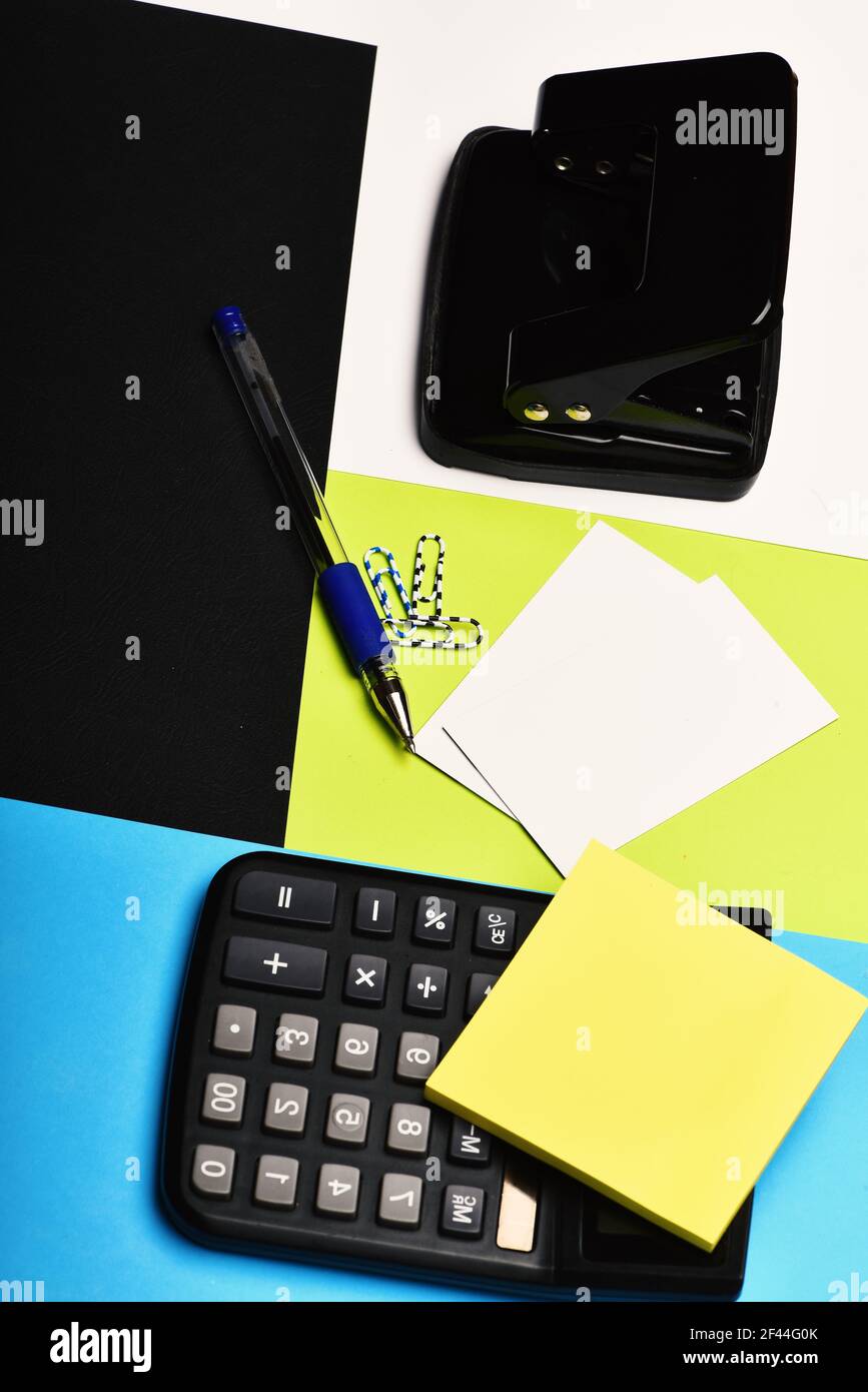 Calculator, hole punch, business cards, note paper, paper clips, pen