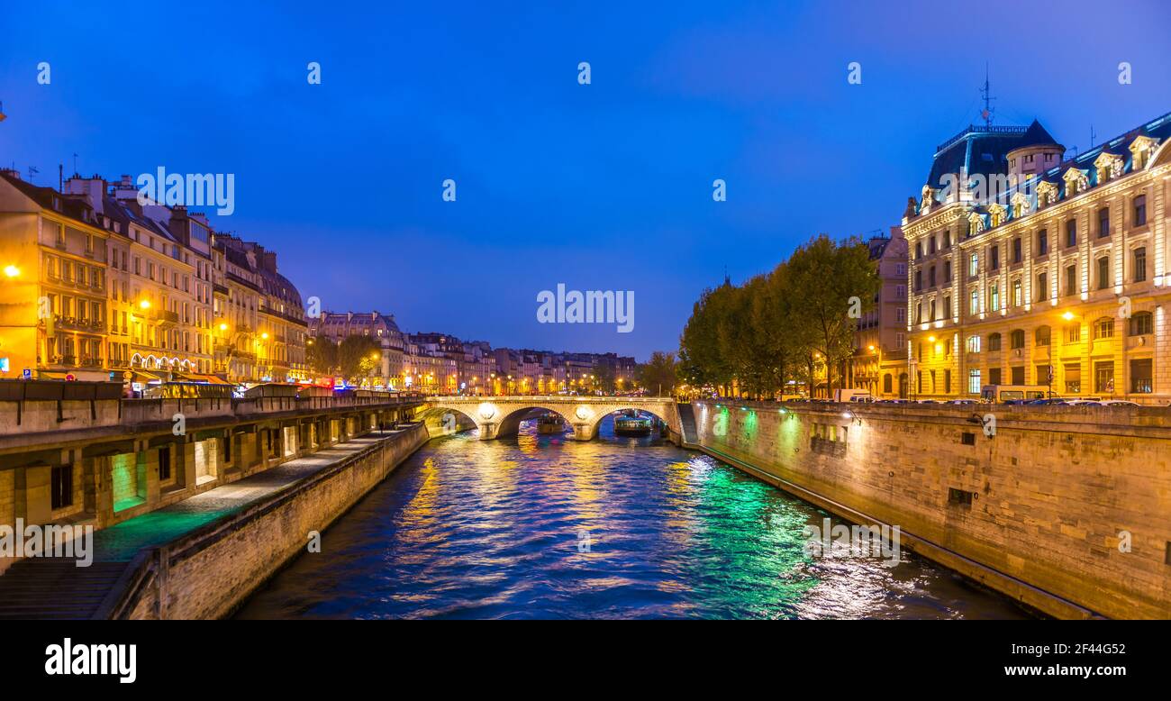 The quays of the Seine and the prefecture and the Saint Michel bridge at night in Paris, France Stock Photo