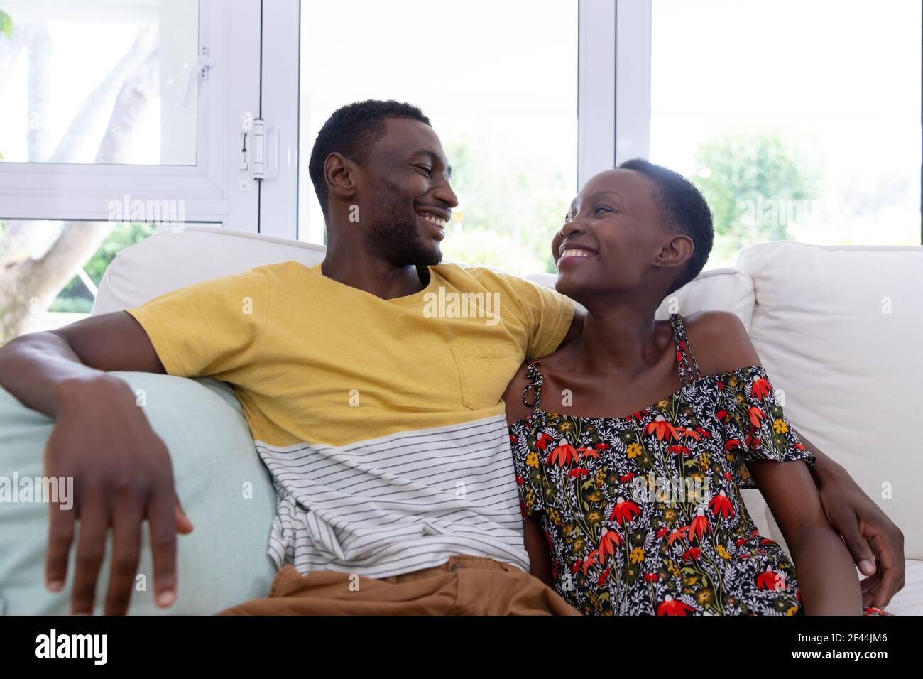 African american couple sitting on sofa embracing and smiling Stock ...