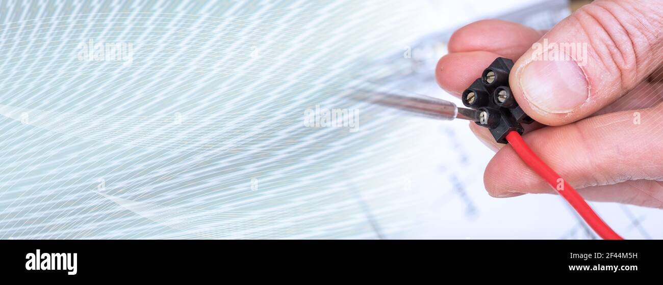Clamping a wire in a connector, closeup; panoramic banner Stock Photo